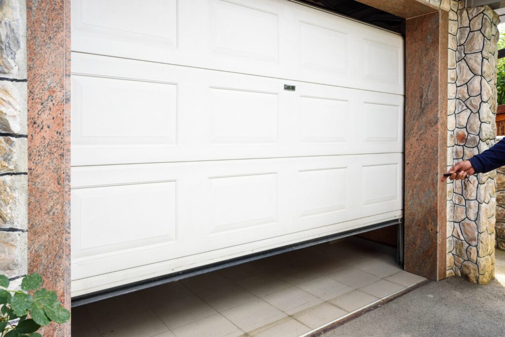 A white garage door that requires garage door maintenance